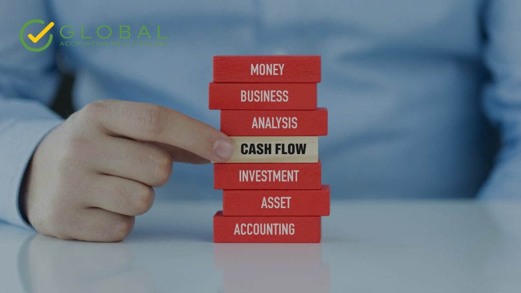 A stack of red blocks with a person grabbing a white block in the center that says cash flow
